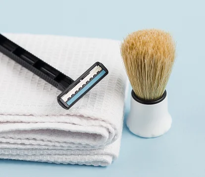 Rasoir et blaireau sur serviettes pliées